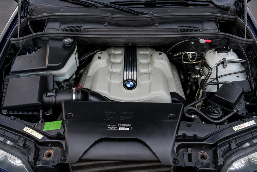 BMW E53 X5 4.8is engine bay with the broad V8 cover, coolant reservoir and surrounding hoses visible